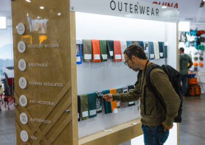 Credit: Keith Fearnow for Outdoor Retailer. A curious attendee feeling a fabric on OR's fabric boards at Outdoor Retailer.